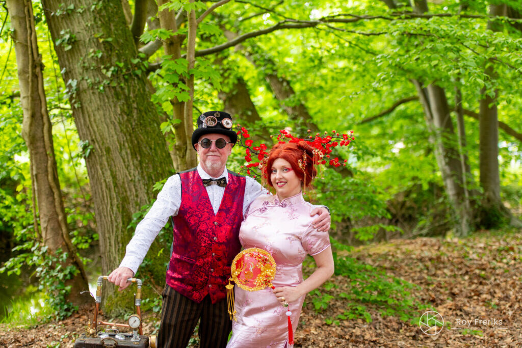 Steampunkheer en vrouw met bloesemkroon samen in het bos