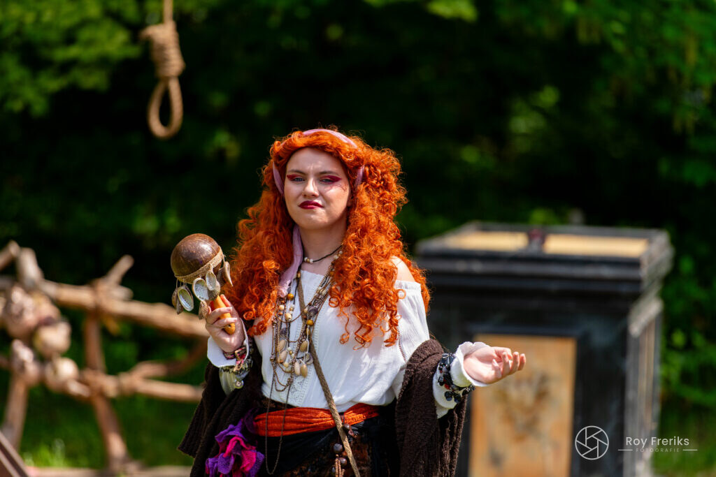 Vrouw met rood krullend haar en schedel bij de galg