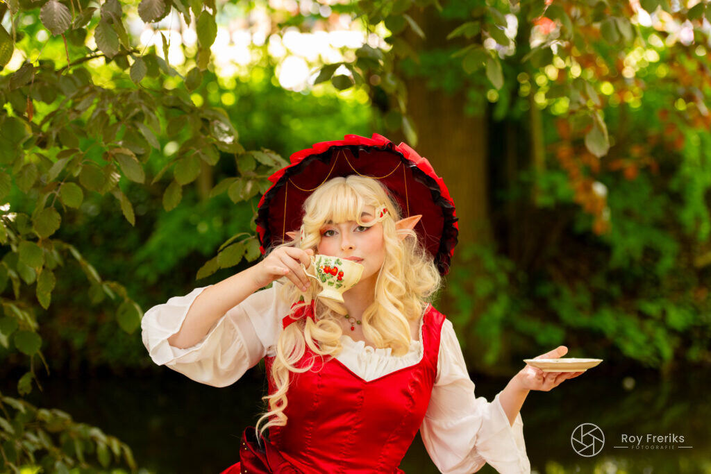 Blonde elf met rode hoed drinkt thee
