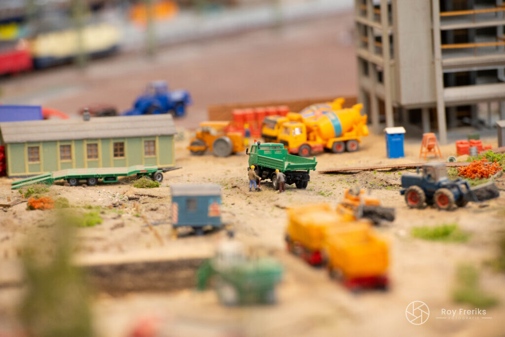 Miniatuur bouwterrein met kleurrijke voertuigen