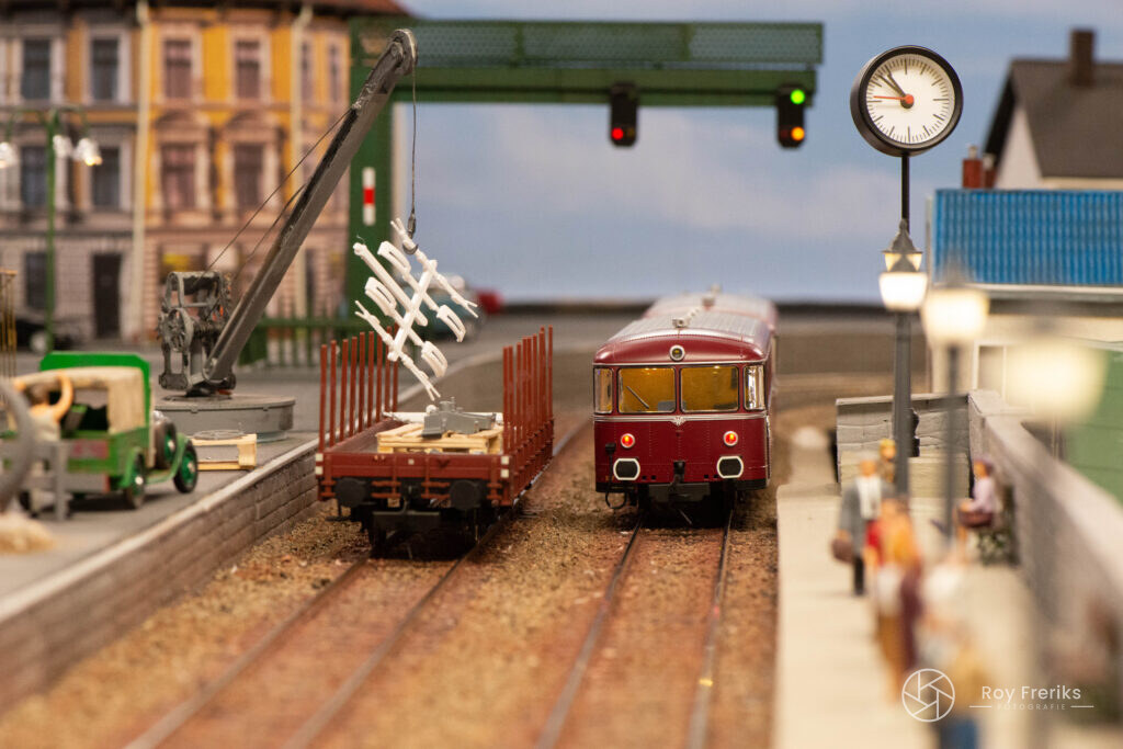 Miniatuur station met rode trein en klok
