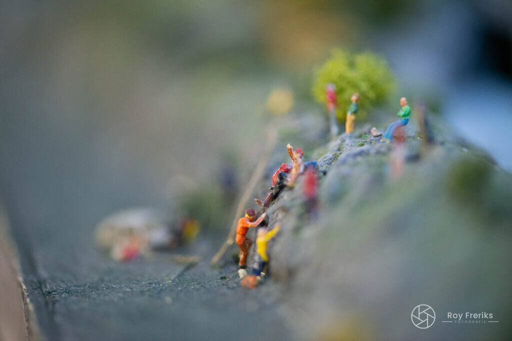 Miniatuur klimmers op een rots