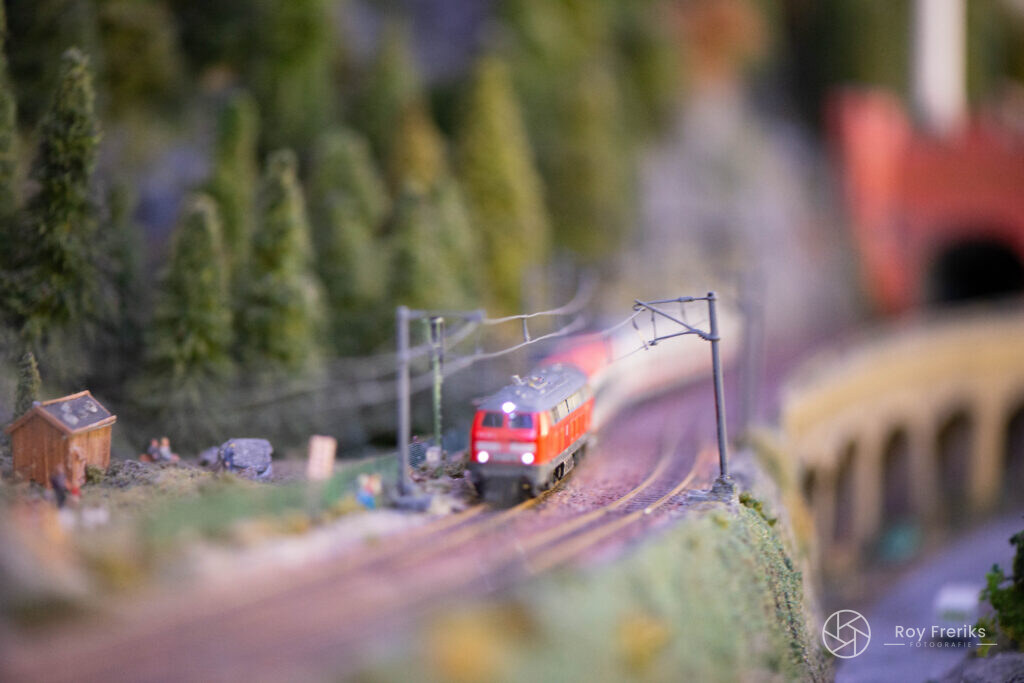 Rode miniatuurtrein in een bocht door de bergen