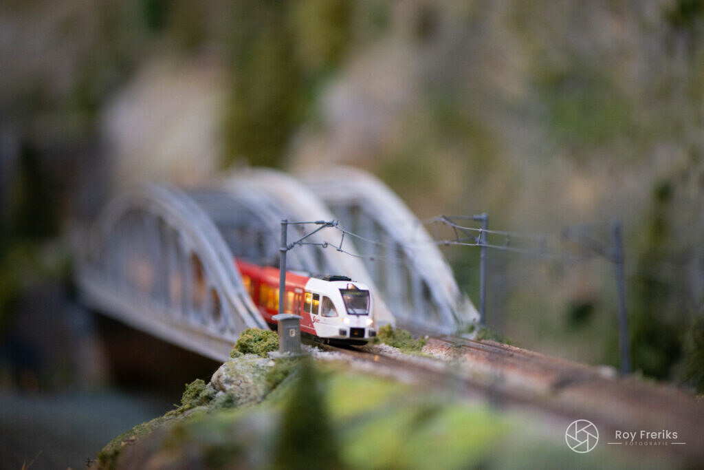 Miniatuurtrein rijdt over een brug