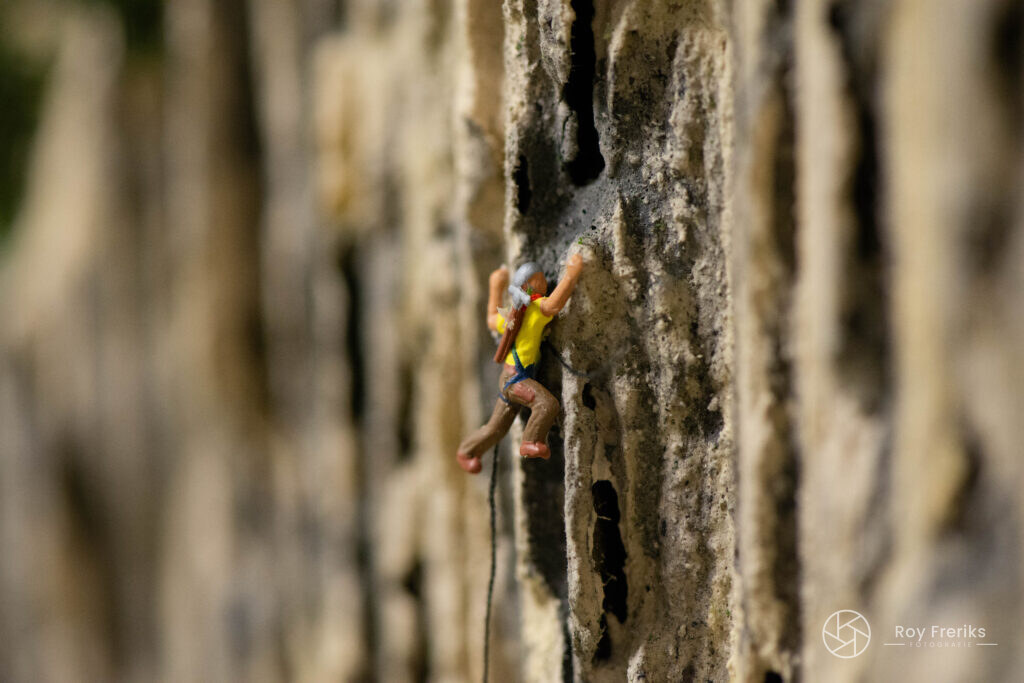 Miniatuur klimmer aan een rotswand