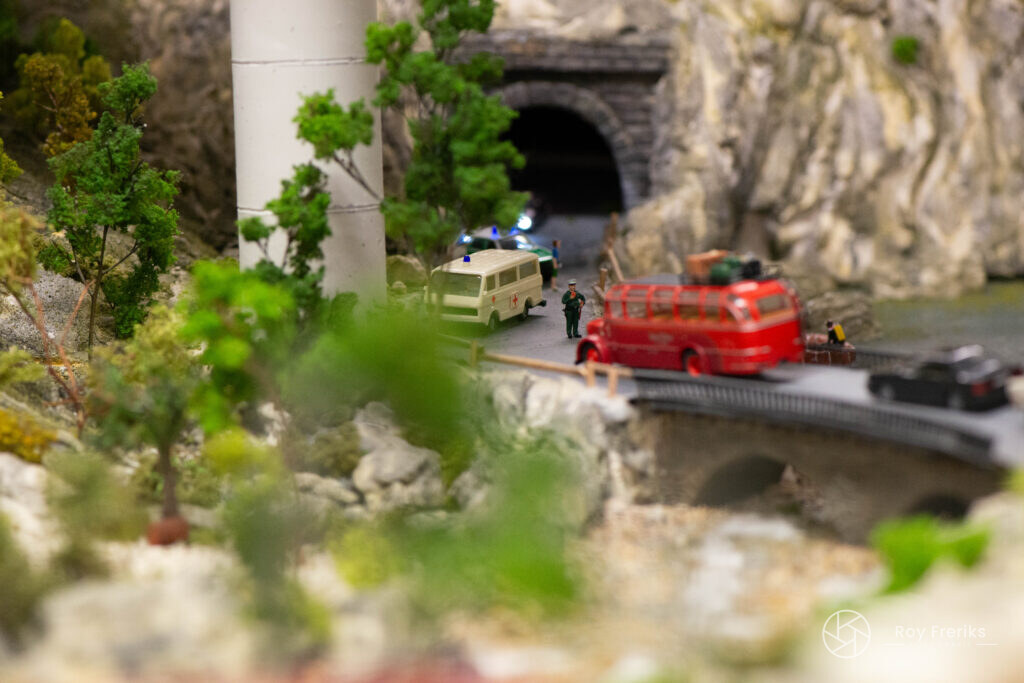 Miniatuur rode bus bij een bergtunnel
