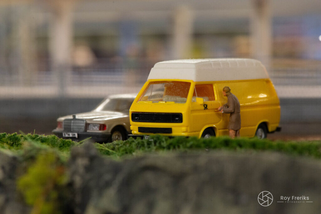 Miniatuur gele bus met chauffeur