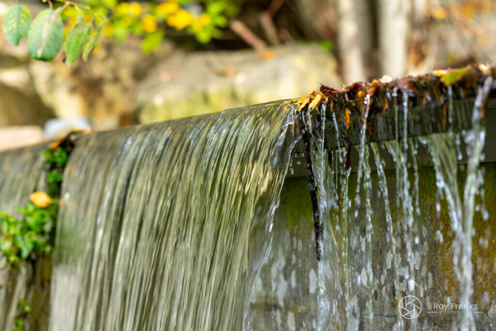 Kleine waterval over rotsen met zacht stromend water