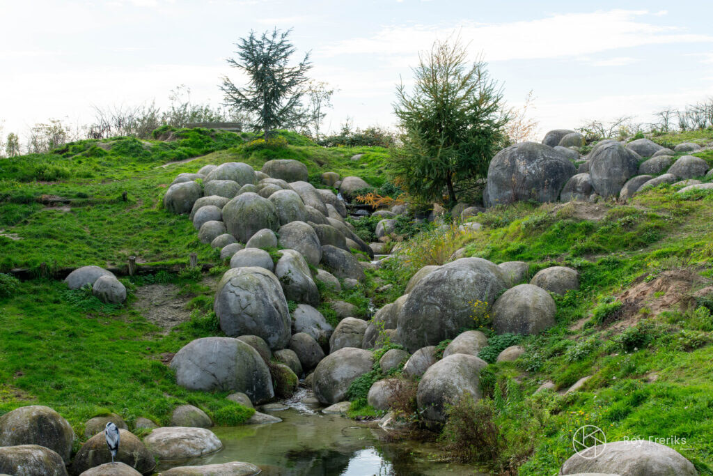 Landschap met grote keien en groene heuvel