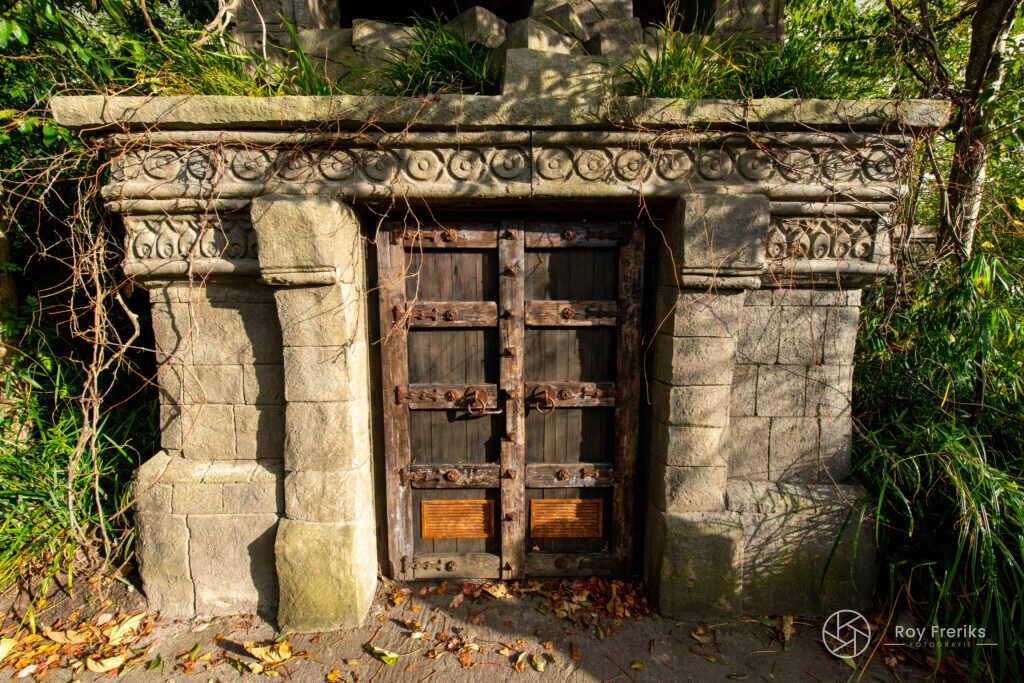 Oude stenen poort met houten deur in de jungle