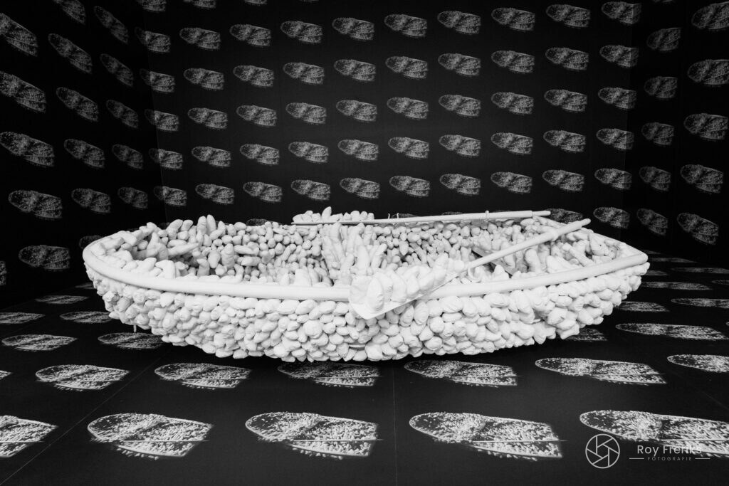 Wit sculptuur van een boot in een zwart-witte zaal