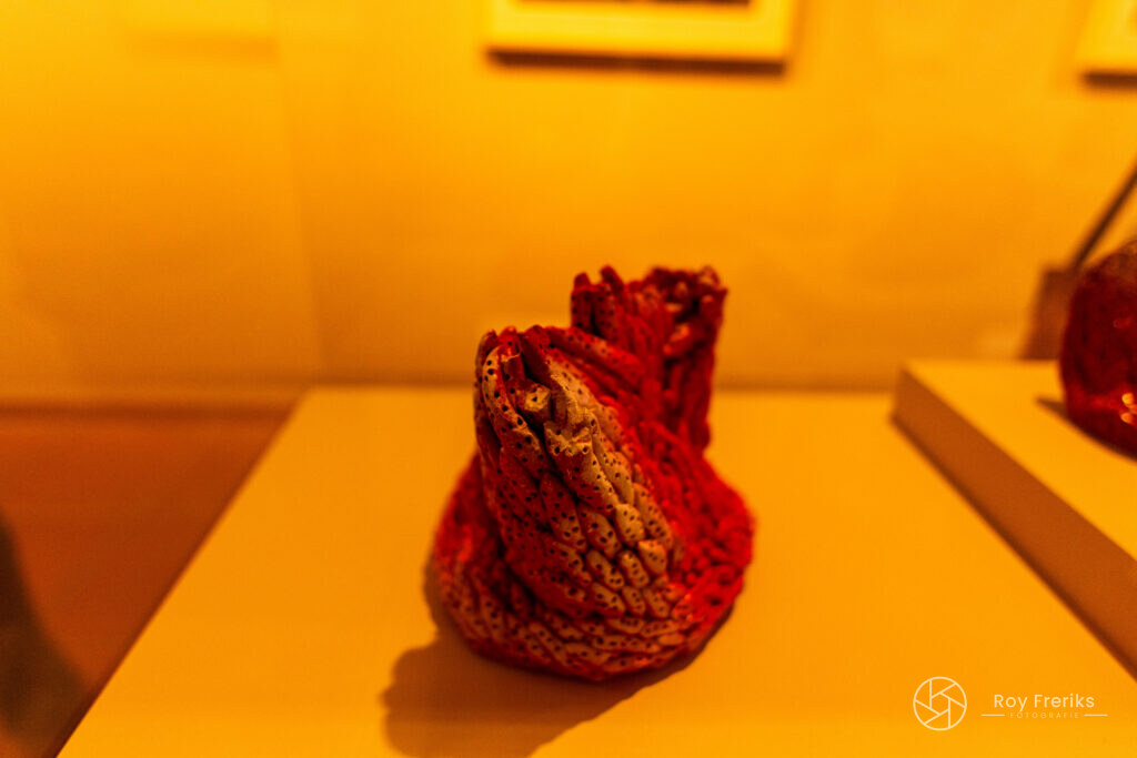 Rood beeld op een sokkel in een warm verlichte zaal