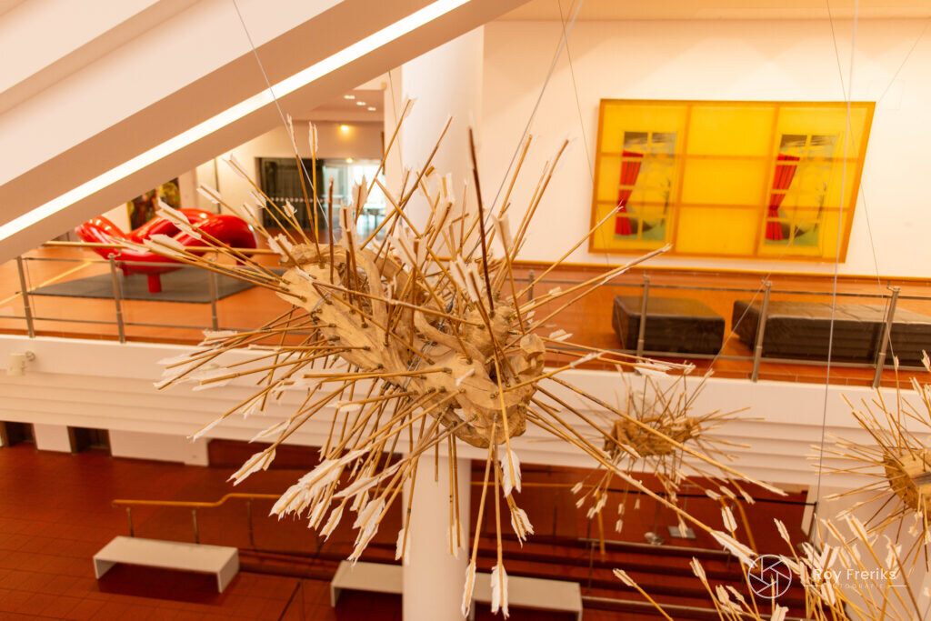 Kunstwerk van stro en takken in een museumzaal