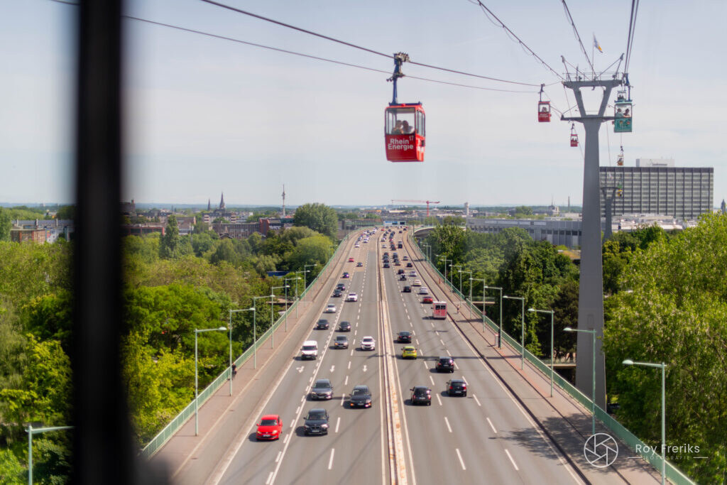 Rode kabelbaangondel boven een drukke weg