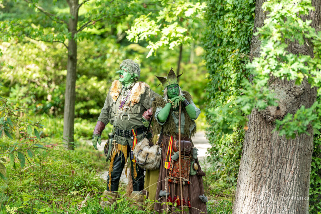 Twee groen geschminkte orks in leren kostuums tussen de bomen