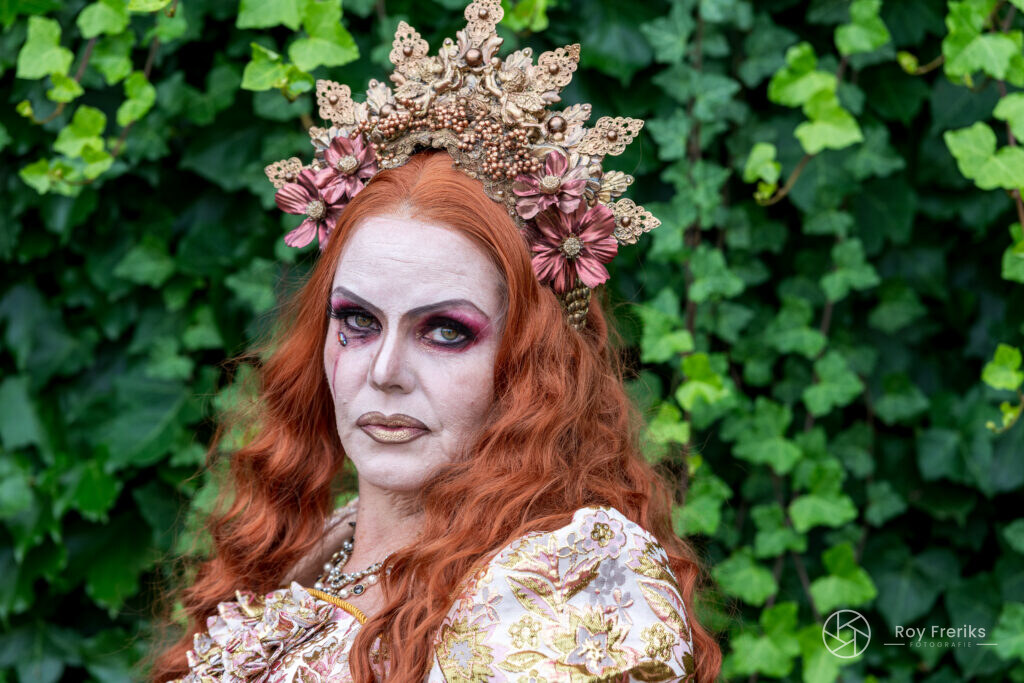 Close-up van een vrouw met rood haar en een gouden kroon voor klimop